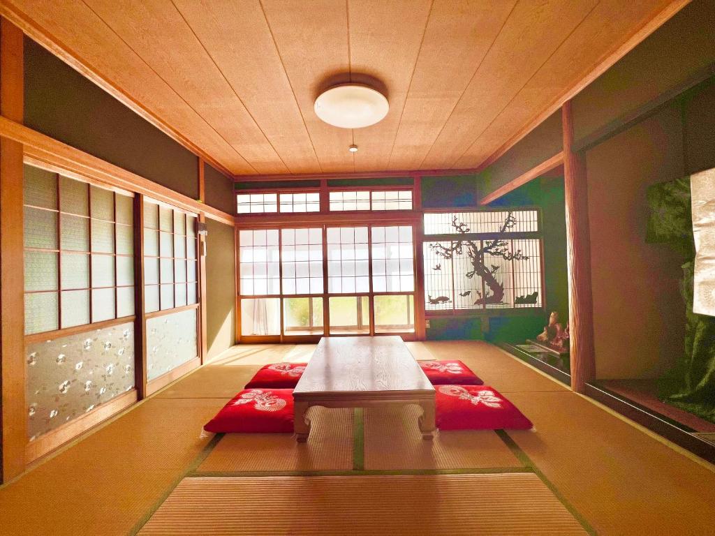 a living room with a table and red mats at 瀬戸内庵Setouchian in Takamatsu