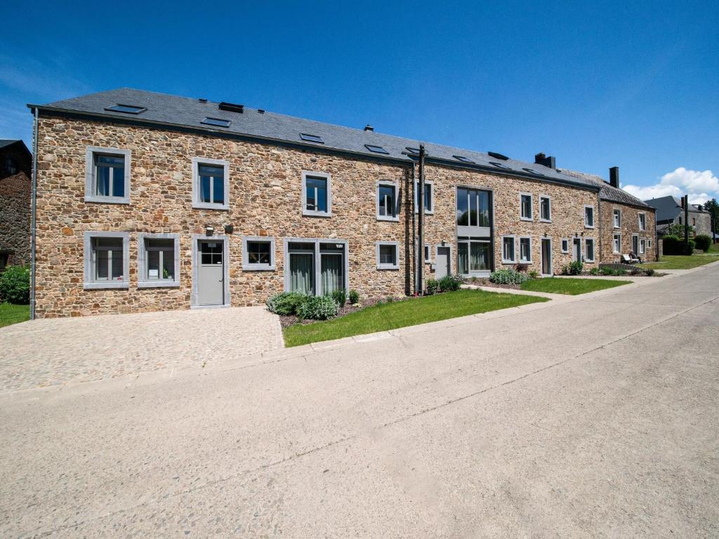 ein großes Backsteingebäude an der Seite einer Straße in der Unterkunft Charming Rural Retreat in Bourseigne-Neuve