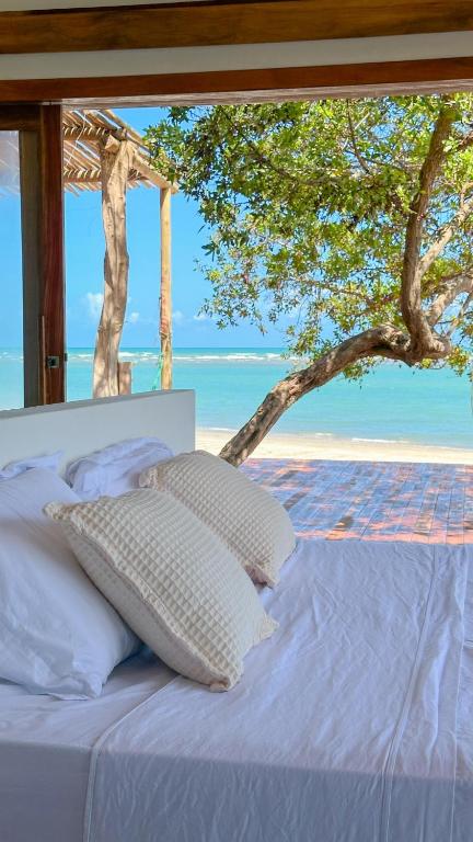 a bed in a room with a view of the ocean at Kiterise Tatajuba in Tatajuba