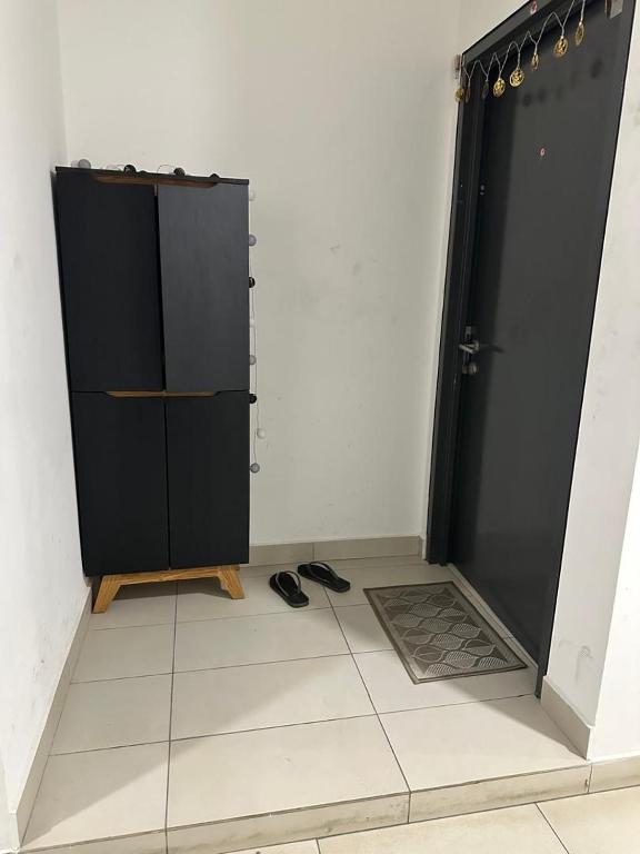 une armoire noire dans une pièce avec porte dans l'établissement VinThris HomeStay, à Shah Alam