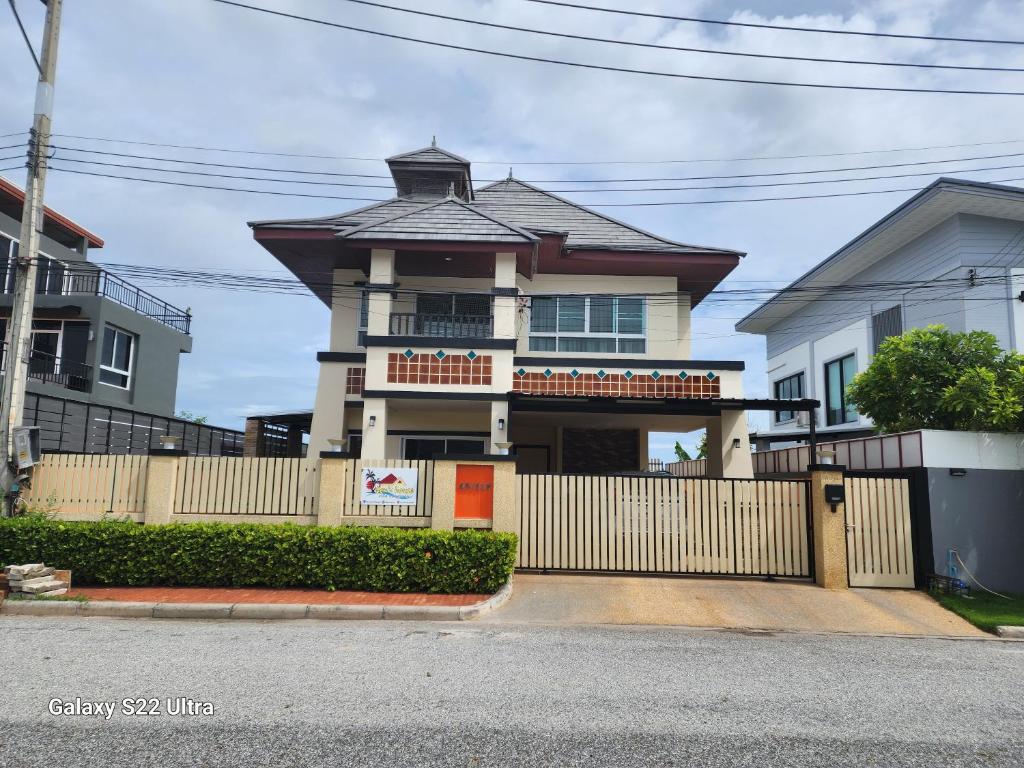 a house with a fence in front of it at Ben's House Bangsaen in Bangsaen