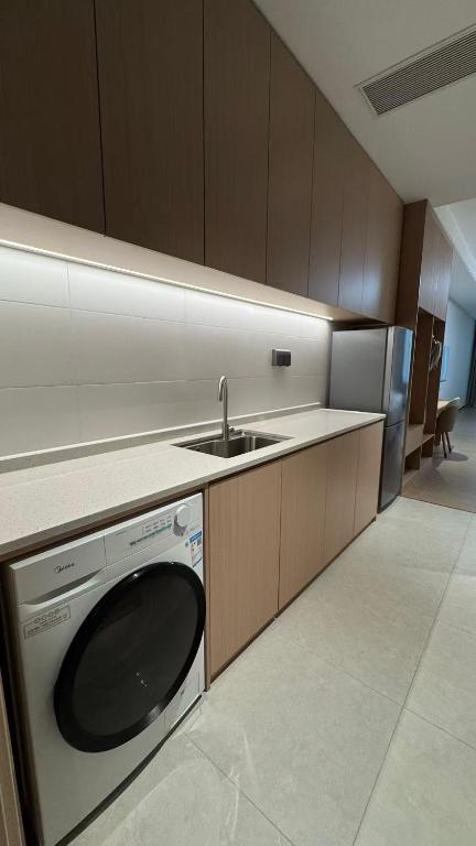 a kitchen with a sink and a washing machine at Also Hotel in Shanghai