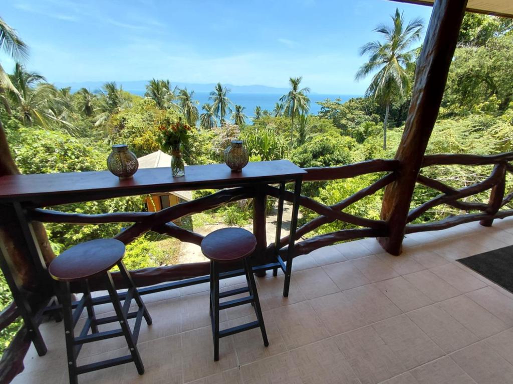 a balcony with a table and two stools at House 2 Bedroom with Seaviews near Haad Rin in Koh Phangan