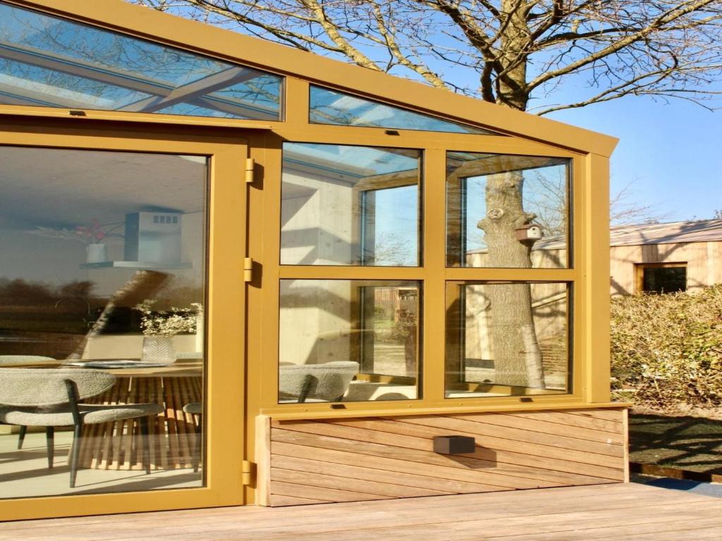 a yellow shed with a window and a table at Group accommodation for 36 guests in Scherpenzeel