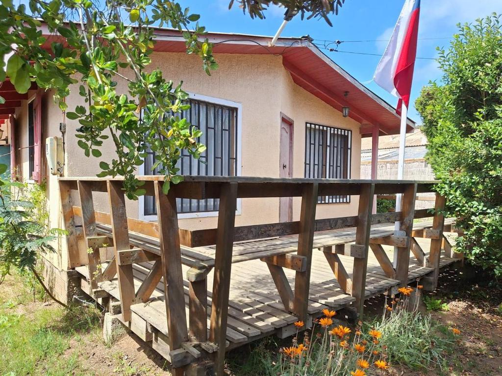 uma casa com um deque de madeira em frente em Cabaña en el Canelillo em Algarrobo