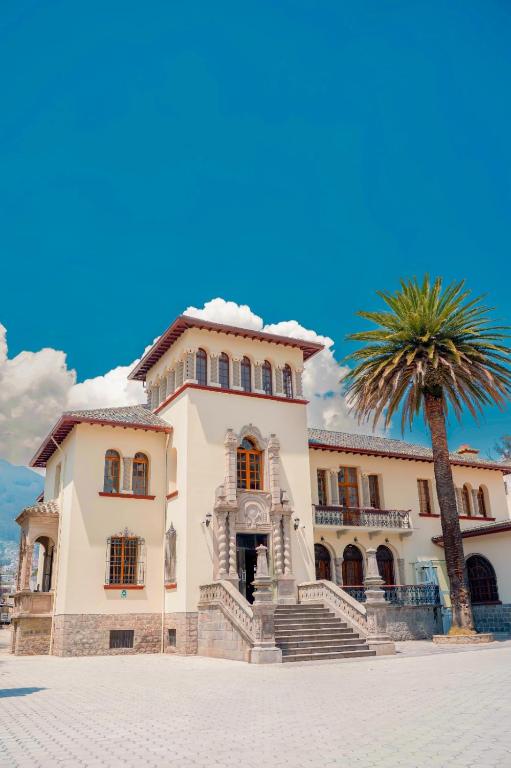 a building with a palm tree in front of it at Hotel Boutique Circasiana Palace in Quito