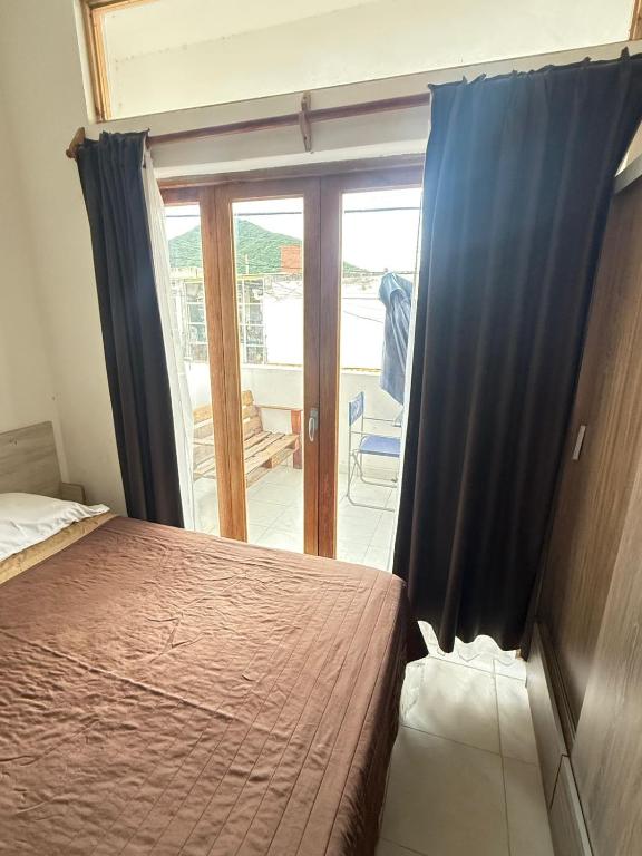 a bedroom with a bed and a sliding glass door at Dulce Descanso in Salta