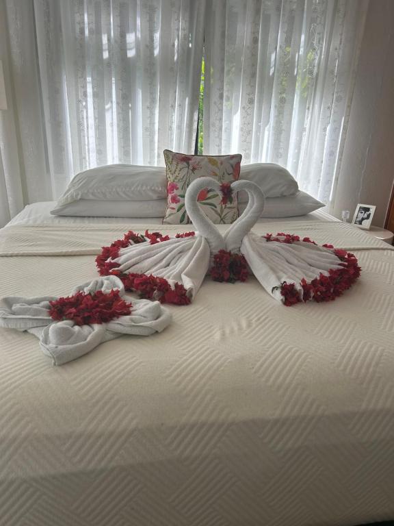 a bed with two hearts and flowers on it at Hotel Villa La Fortuna in Filipina