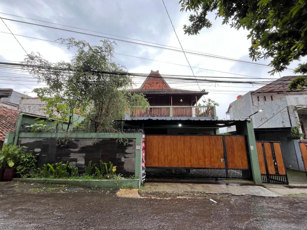 a house with a wooden gate and a house at Villa Murah Joglo Sariwangi in Cihanjuang 1