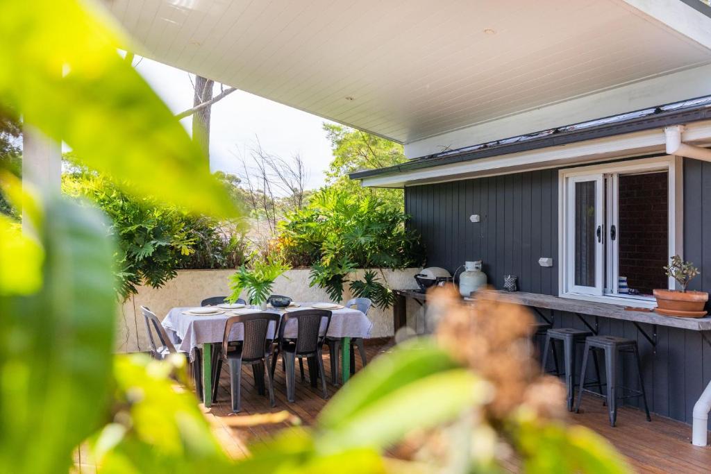 a patio with a table and chairs on a patio at Bluegum Beach Stay in Narrawallee