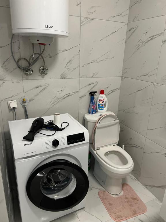 uma casa de banho com uma máquina de lavar roupa e um WC em The Hot Spot em Kosovo Polje