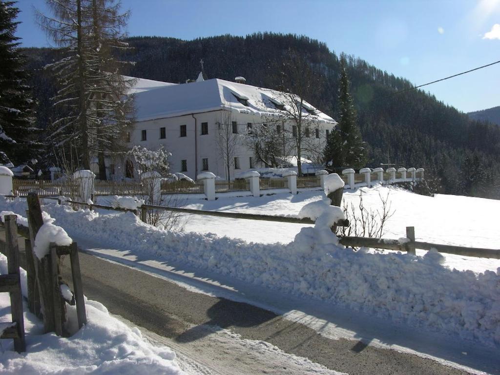 uma cerca coberta de neve em frente a um edifício em Berg Castle Klösterle em Zedlitzdorf