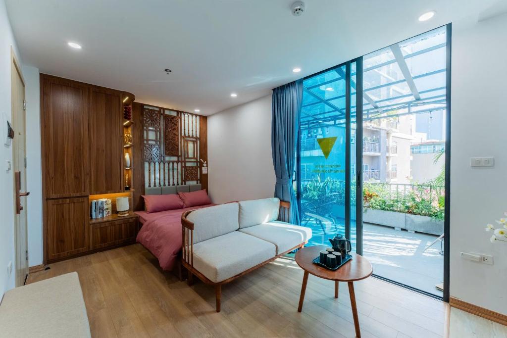 a living room with a couch and a bed and a window at Caelistay in Hanoi
