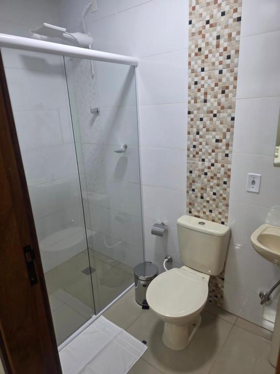 un bagno con wc e doccia in vetro di Pousada Alvorada a Engenheiro Coelho