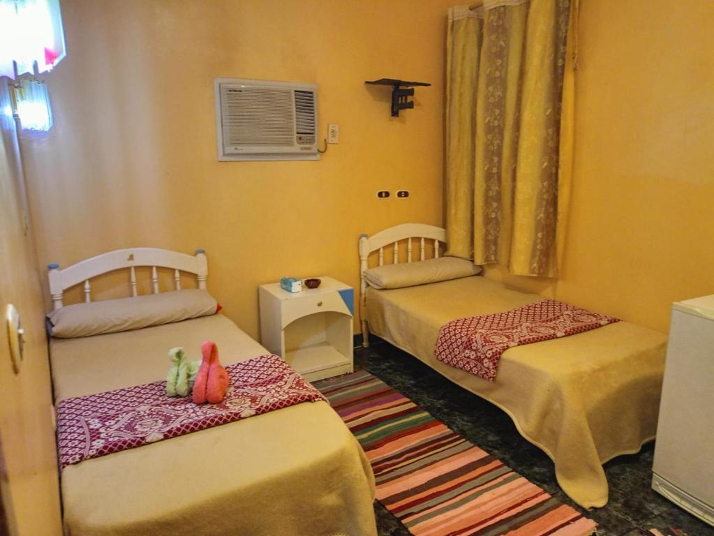 2 camas en una habitación pequeña con paredes amarillas en oasis panorama hotel, en Bawati