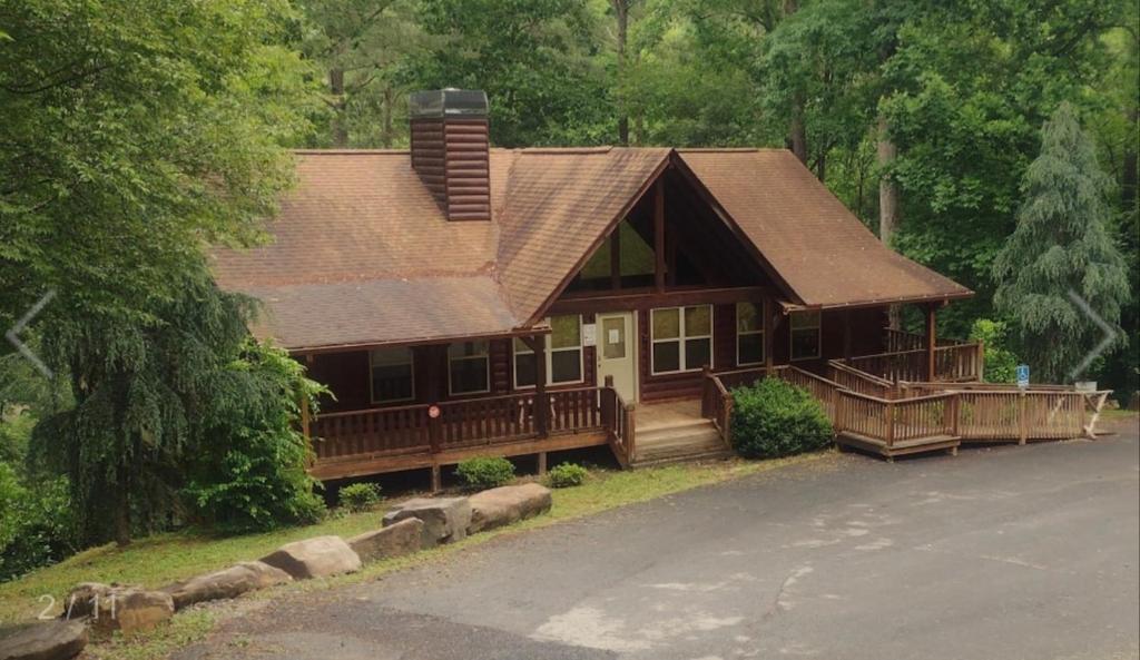 una grande casa di legno con un portico e un tetto di North Ga Hideaway a Ranger