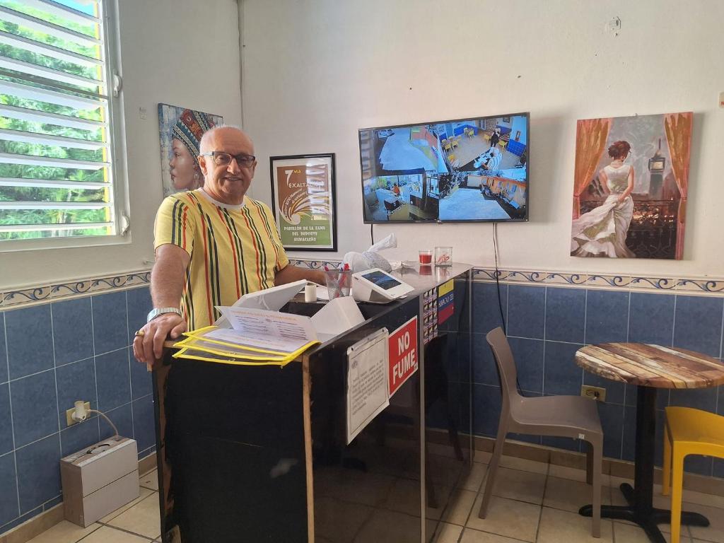 a man standing at a counter in a restaurant at Humacao Guest House 4 in Humacao