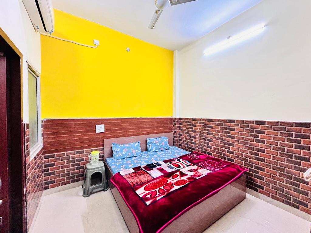 Habitación con cama en una pared de ladrillo en shri radha ji guest House, en Vrindāvan