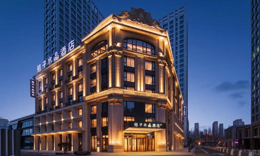 a large building with lights on the side of it at Orange Crystal Hotel Harbin Qunli in Harbin