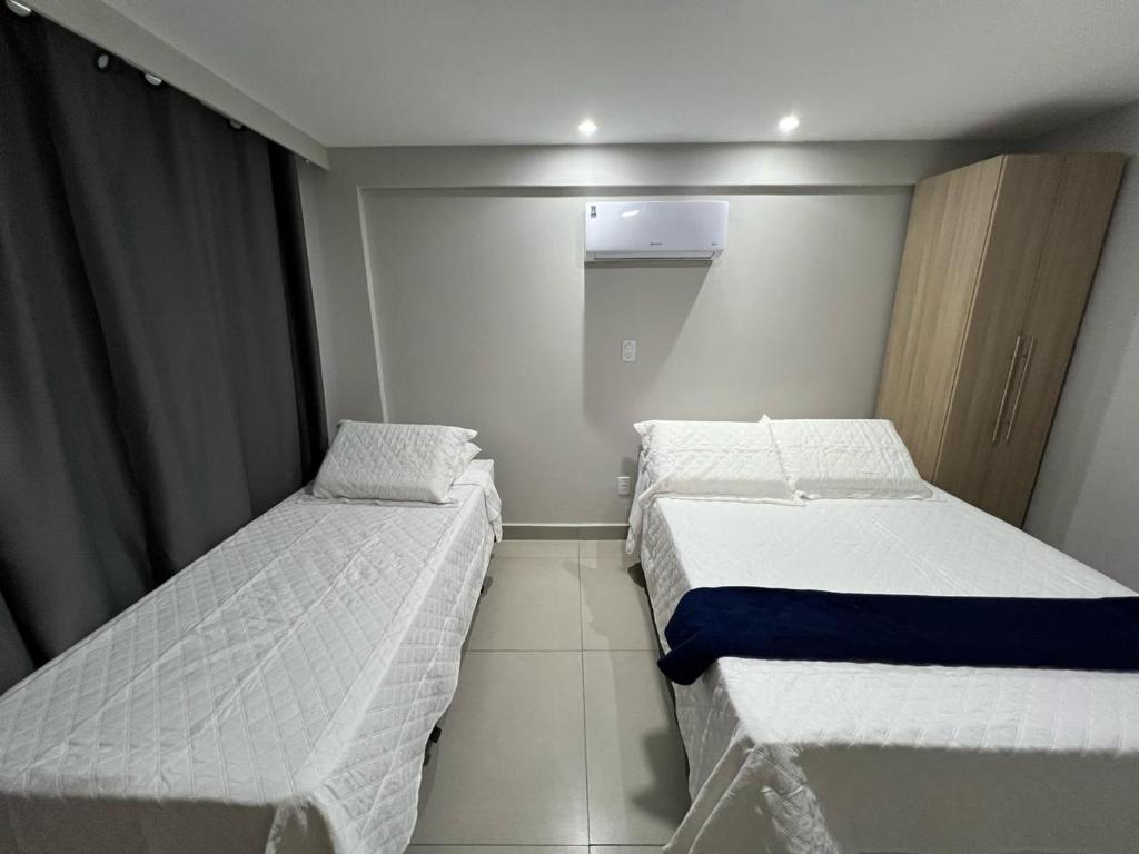 a small room with two beds and a window at Catamarã Pé na Areia in Angra dos Reis