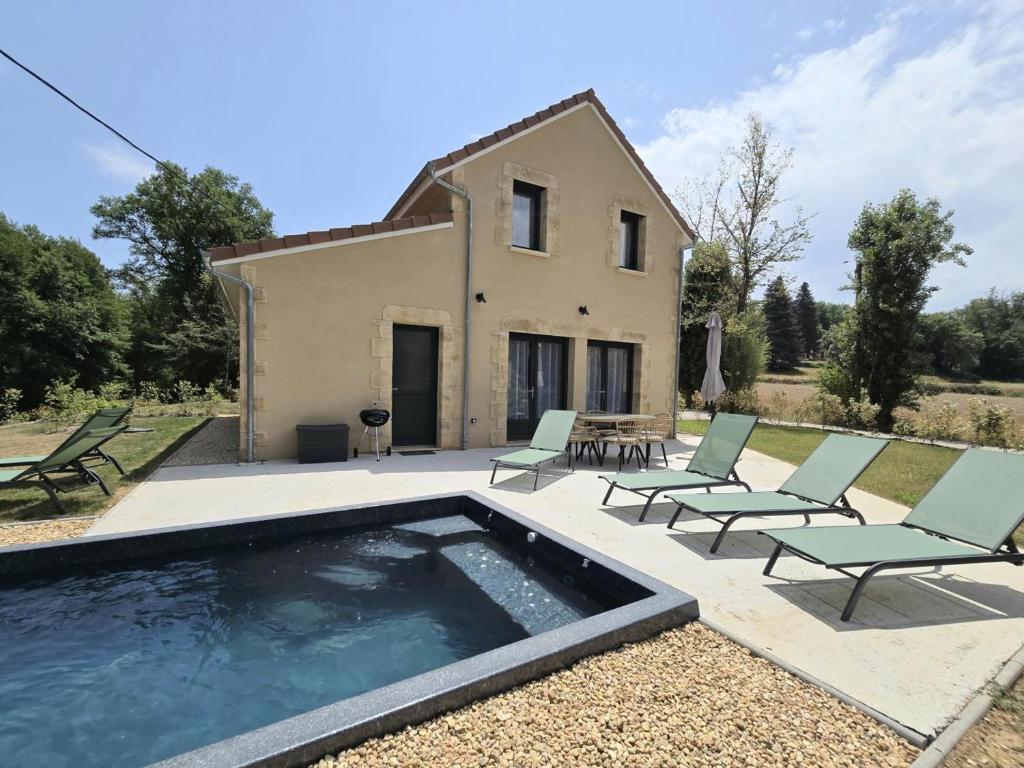 a villa with a swimming pool in front of a house at Charmante maison avec piscine chauffée privée au cœur du Périgord Noir - FR-1-616-530 in Prats-de-Carlux