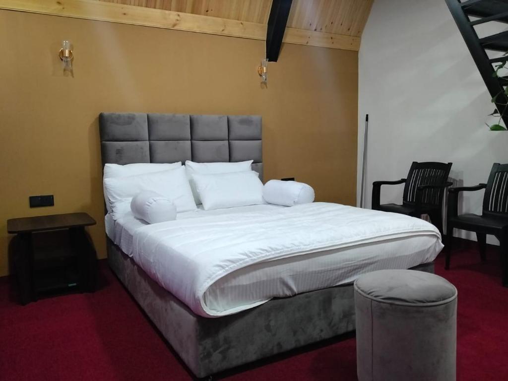 a bedroom with a large bed with white sheets and pillows at Bliss den in Bandarawela