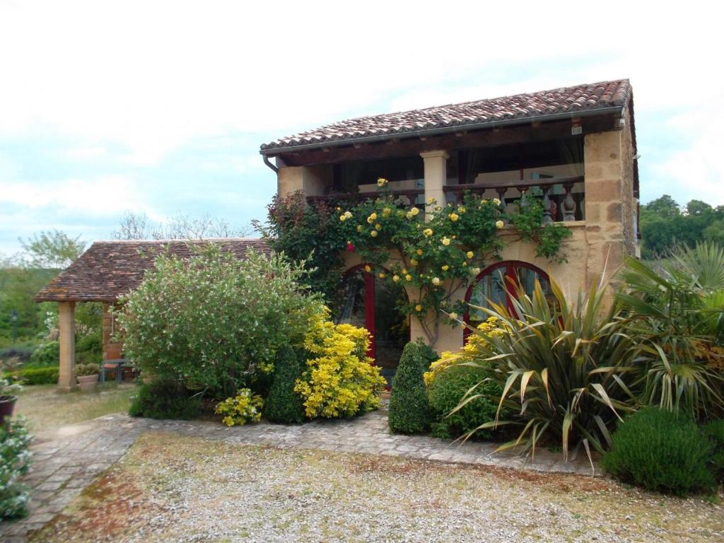 un jardín con un edificio con un ramo de flores en Gîte Confortable à Saint-Sulpice-d'Excideuil avec Internet - FR-1-616-533, en Fonvielle