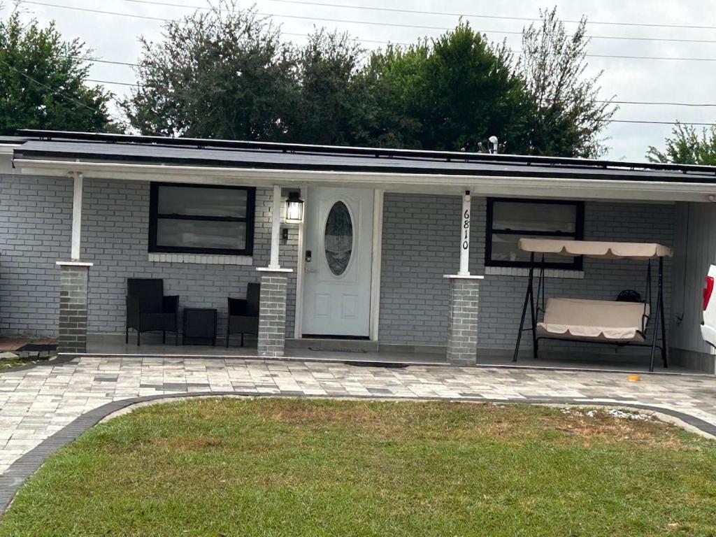 a small brick house with a porch and a couch at Luxury&Home in Tampa