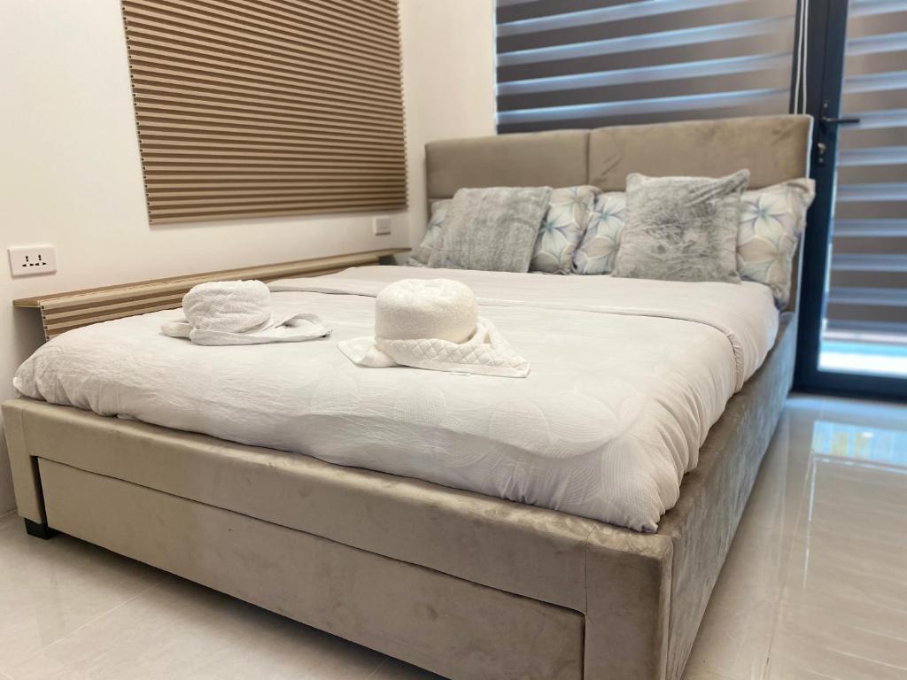 a bed with two towels and two hats on it at City Clou in Cebu City