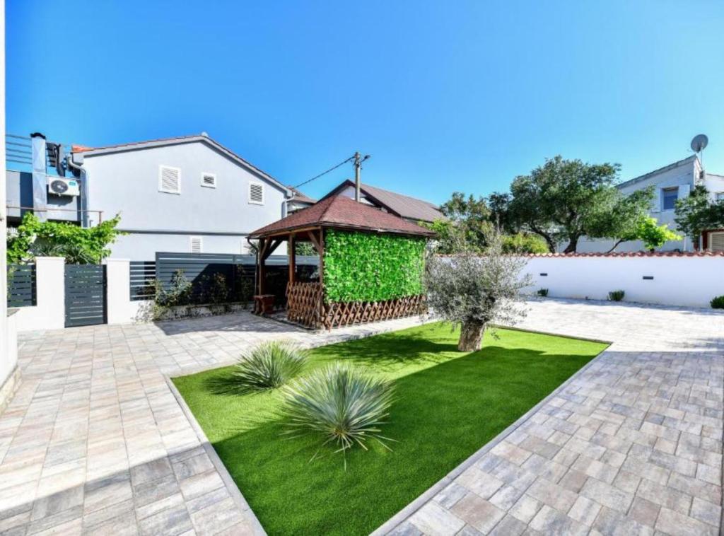 a garden with a gazebo and grass at Villa Kate in Pašman