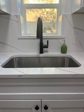 Un fregadero en una cocina con una ventana encima. en Zenergy at Sunshine Mile, Close to UA, Downtown, 4th Ave, Disc Golf, dogs OK, 2 bedroom, en Tucson