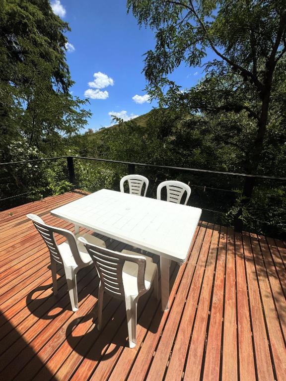 a white table and chairs on a wooden deck at Cedro Azul in La Cumbre