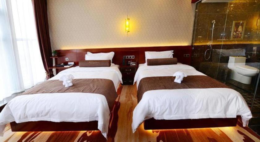 Una cama o camas en una habitación de James Joyce Coffetel Golmud Huaxing Plaza Branch