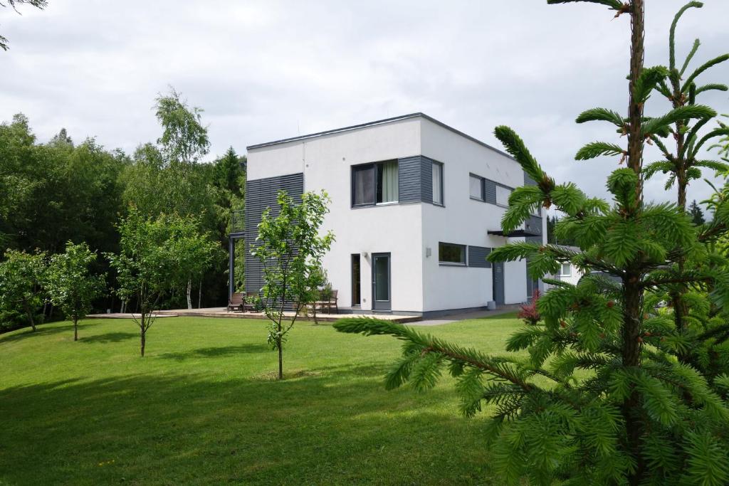 a white house with a green yard with trees at Villa Saskia in Otepää