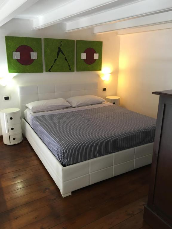 una camera da letto con un letto bianco e quadri verdi sul muro di Loft Of Love a Cagliari