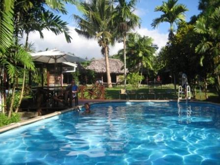 a large swimming pool with a person in the water at The Samoan Outrigger Hotel in Apia