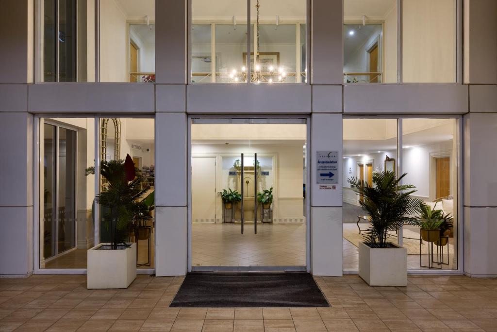 a lobby of a building with potted plants at Beaumont Apartments in Mount Maunganui