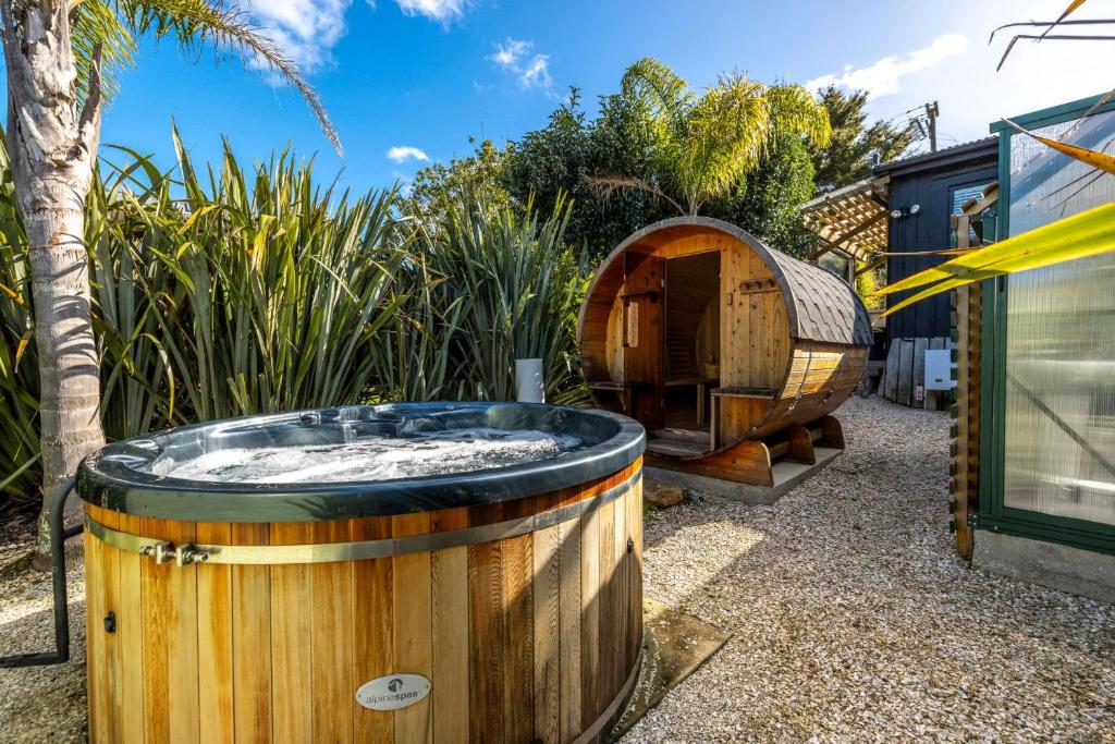 a wooden tub in a yard with a hobbit house at Welcome Cottage - Stay Waiheke in Oneroa