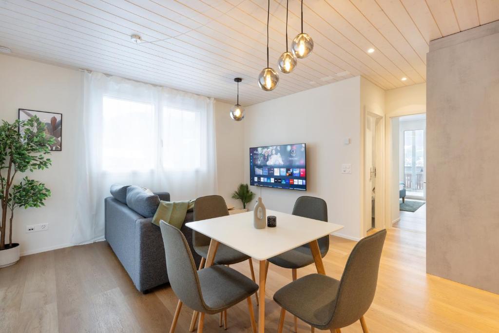 a living room with a table and chairs and a couch at Mountain view with balcony and free parking in Lungern