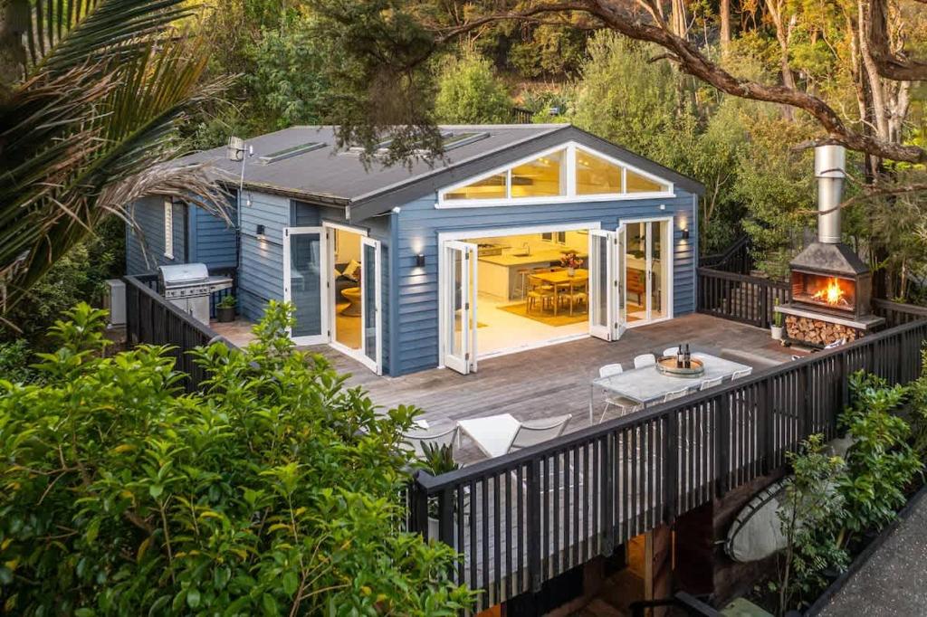 a tiny house with a deck and a grill at Skyview Onetangi - Stay Waiheke in Waiheke Island