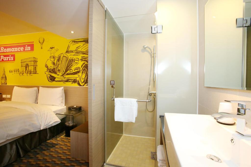 a bathroom with a bed and a shower and a sink at Chiayi Look Hotel in Chiayi City