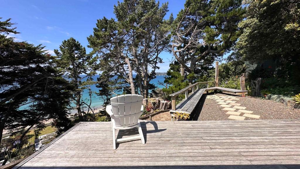 a white chair sitting on top of a wooden deck at Viewpoint - Stay Waiheke in Onetangi