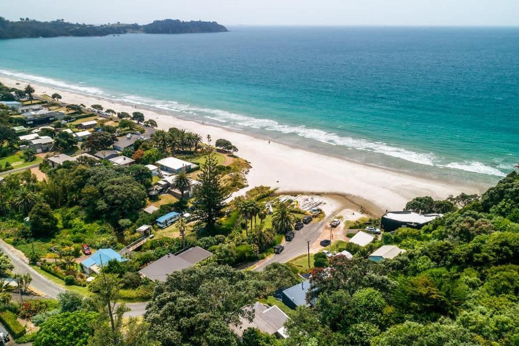 an aerial view of a beach with houses and the ocean at Sunshine Cottage by the Sea - Stay Waiheke in Onetangi