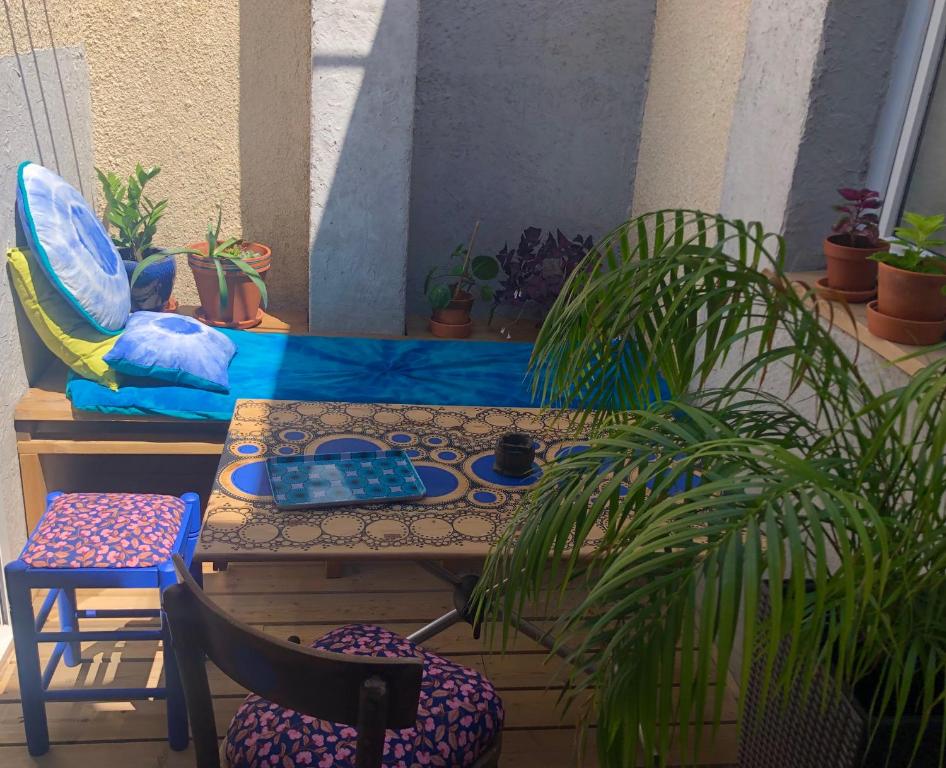 een terras met een tafel, stoelen en planten bij Chez Corinne in Valence