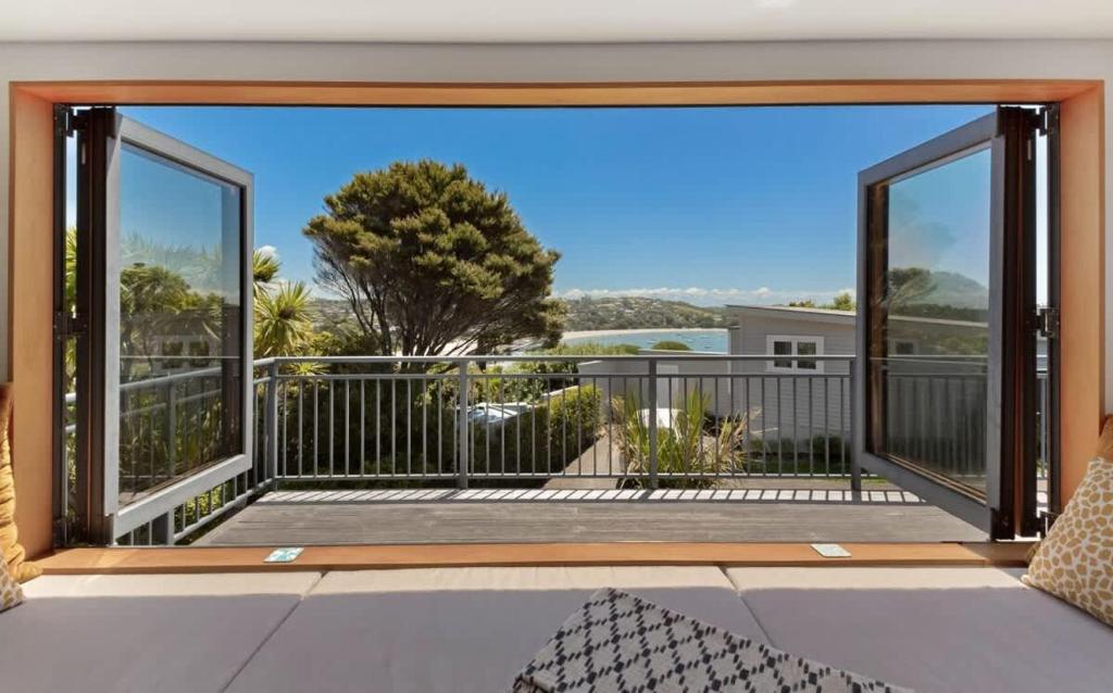 an open balcony with a view of the ocean at The Cove at Little O - Stay Waiheke in Oneroa