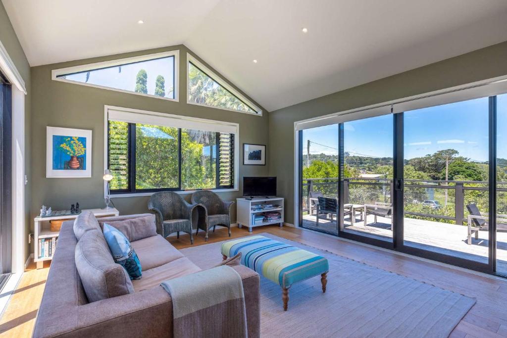 uma sala de estar com um sofá e uma janela grande em Art Lovers Retreat - Stay Waiheke em Onetangi