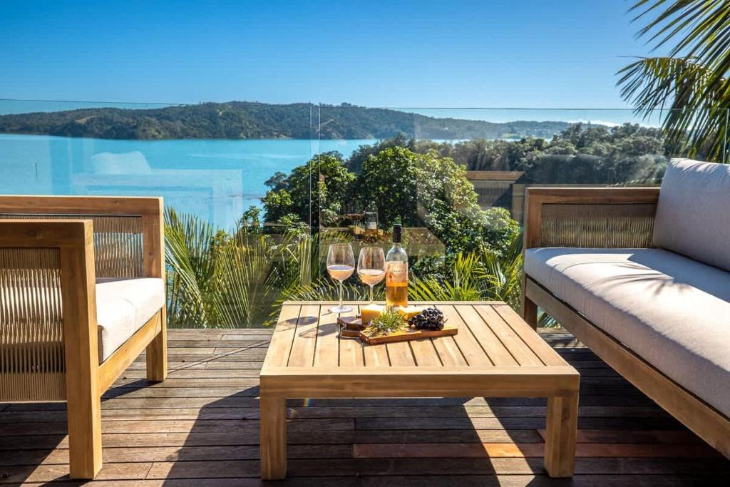 Te Whau BayPalms on Kennedy Point - Stay Waiheke的天井配有带酒杯的桌子