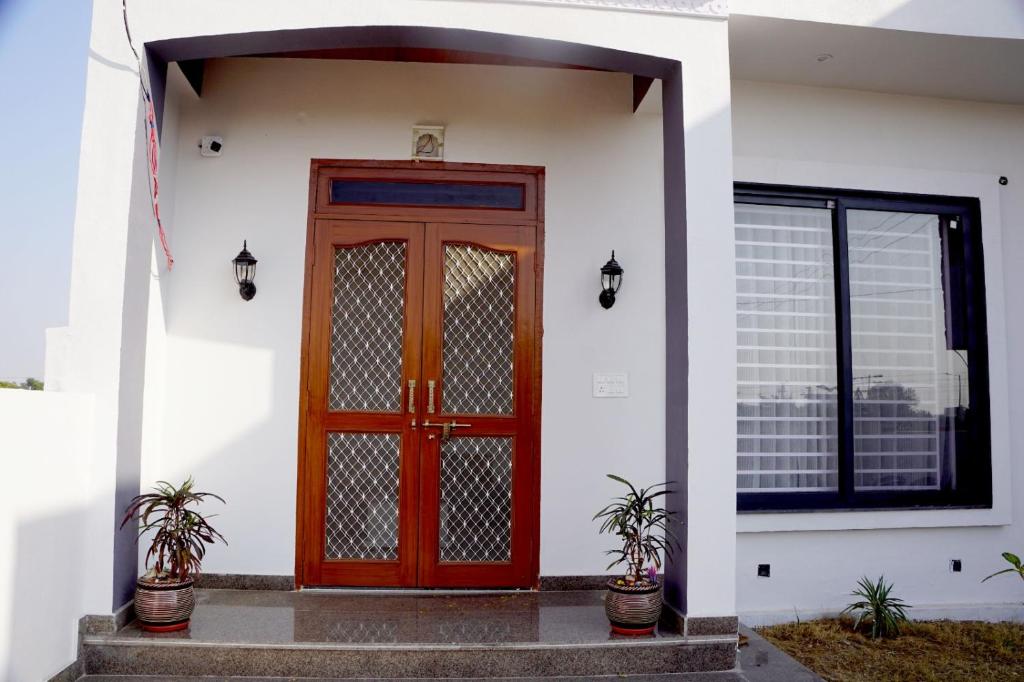 a red door on the side of a white house at Meg's Homestay in Jairāmpura