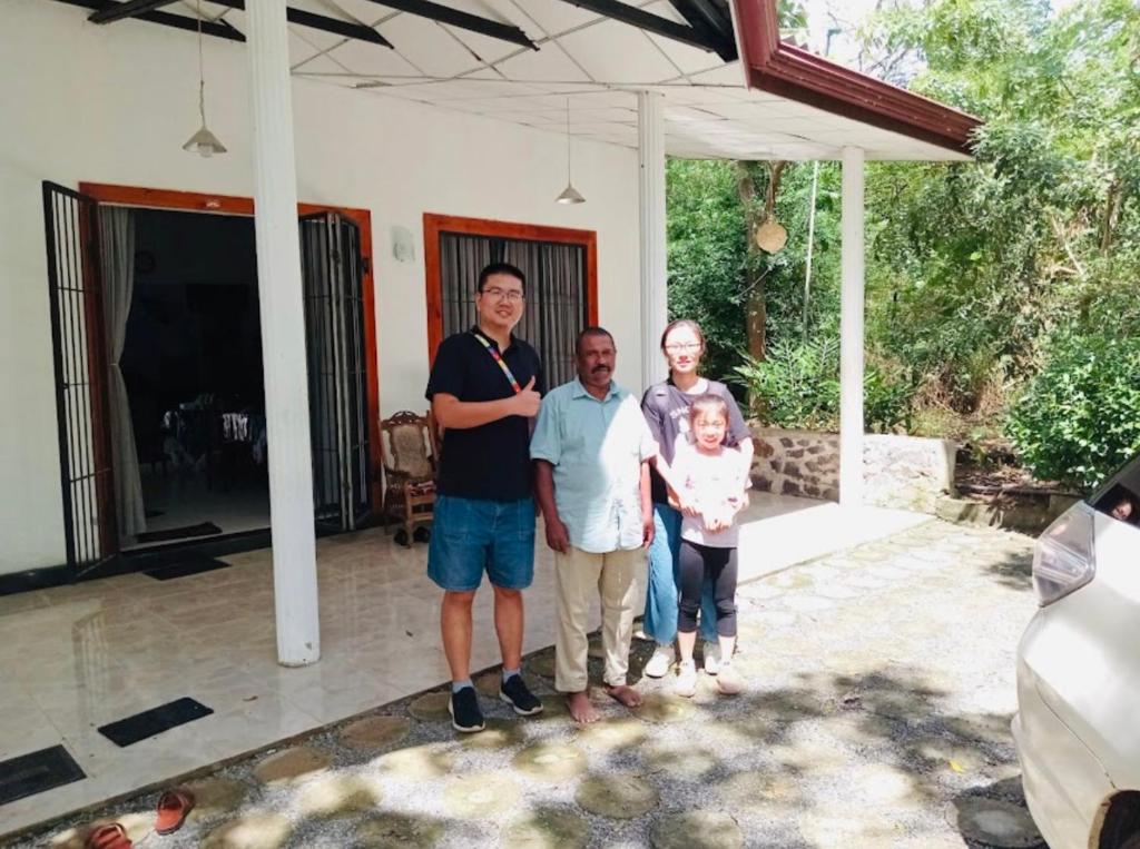 a group of people standing in front of a house at Neem safari lodge Yala in Tissamaharama