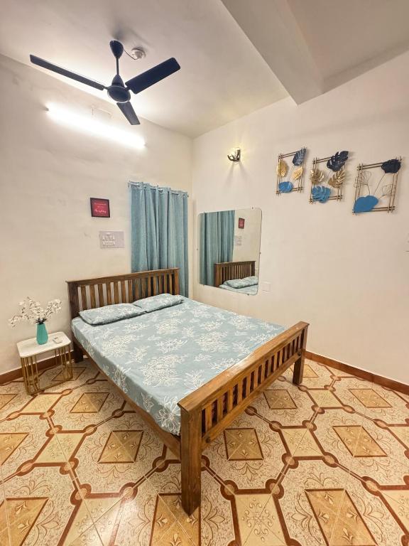 a bedroom with a bed and a ceiling fan at Casa Fiesta Pondy in Pondicherry